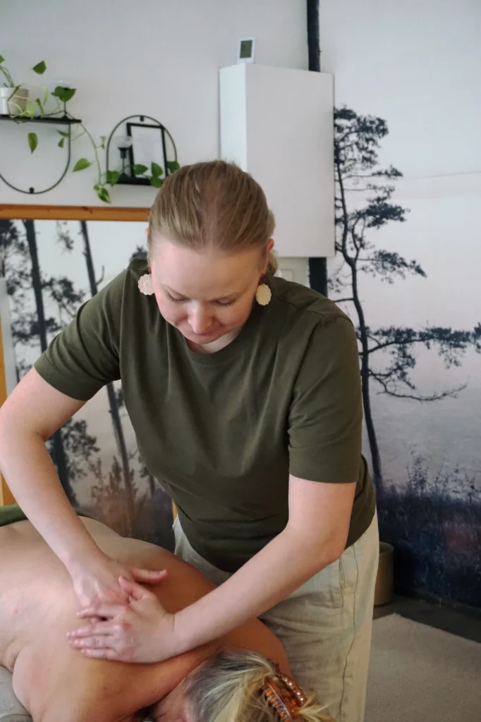 Hierojan kädet työskentelevät asiakkaan selässä