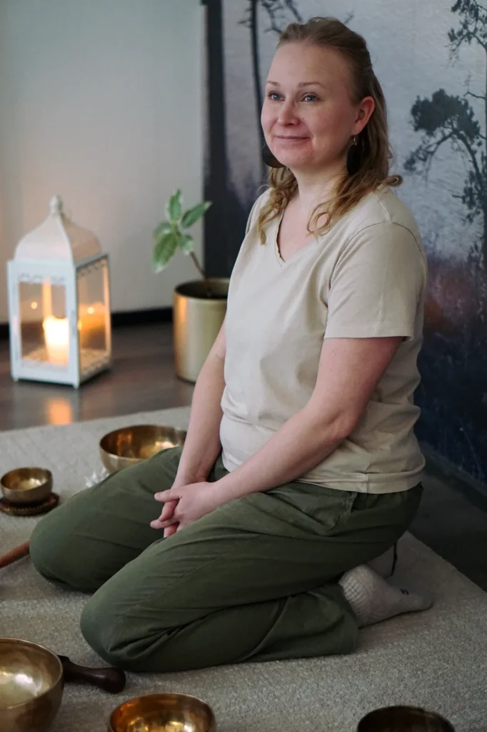 Jonna Metsäkylä hoitohuoneessaan äänimaljojen äärellä