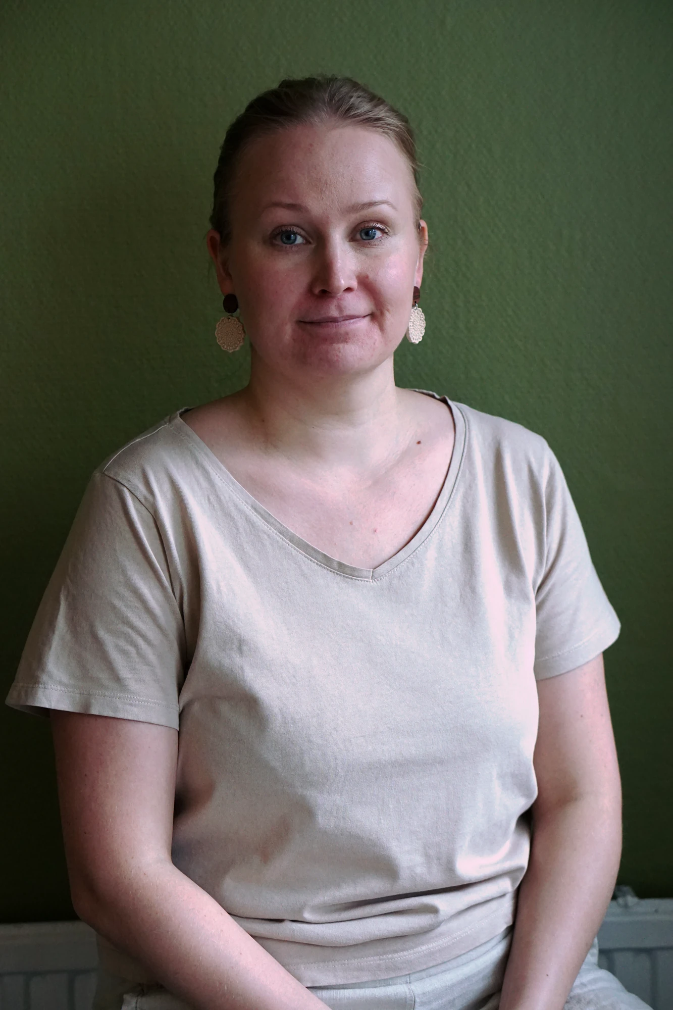 Jonna Metsäkylän muotokuva vihreää seinää vasten